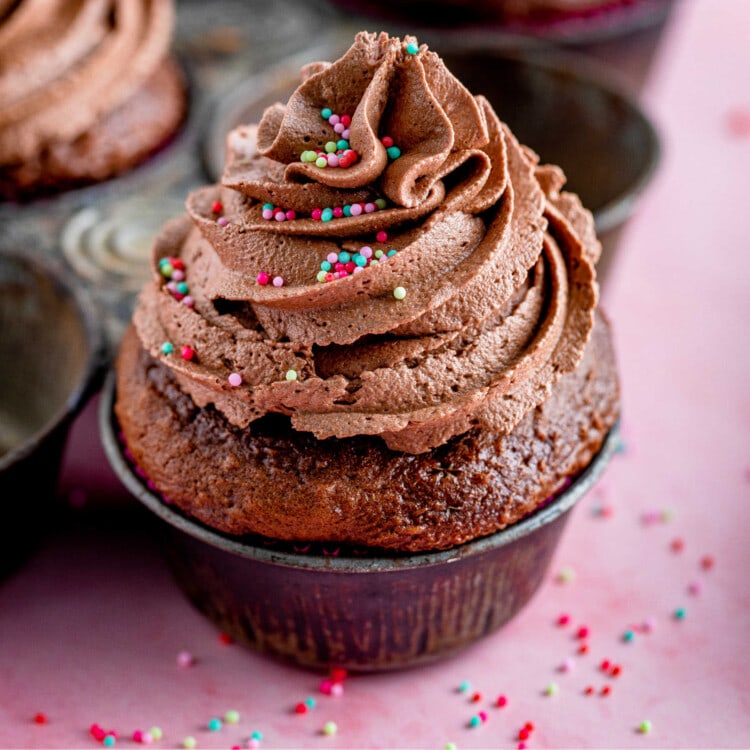 Cupcake topped with chocolate buttercream frosting on a chocolate cupcake