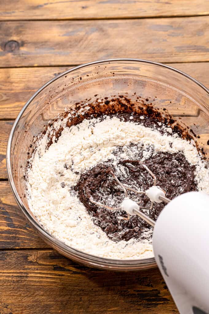 Hand mixer mixing together chocolate cookie dough.