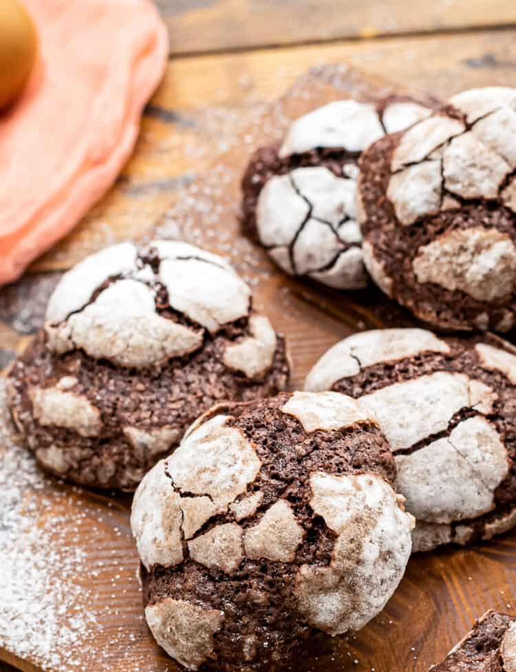 Wooden board with Chocolate Crinkle Cookies stacked on it