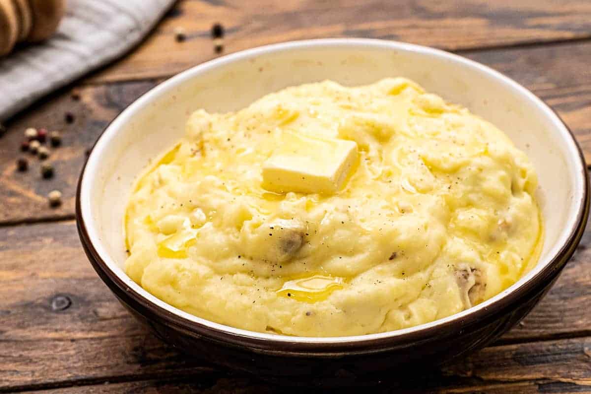 Bowl of homemade Mashed Potatoes topped with a slab of butter