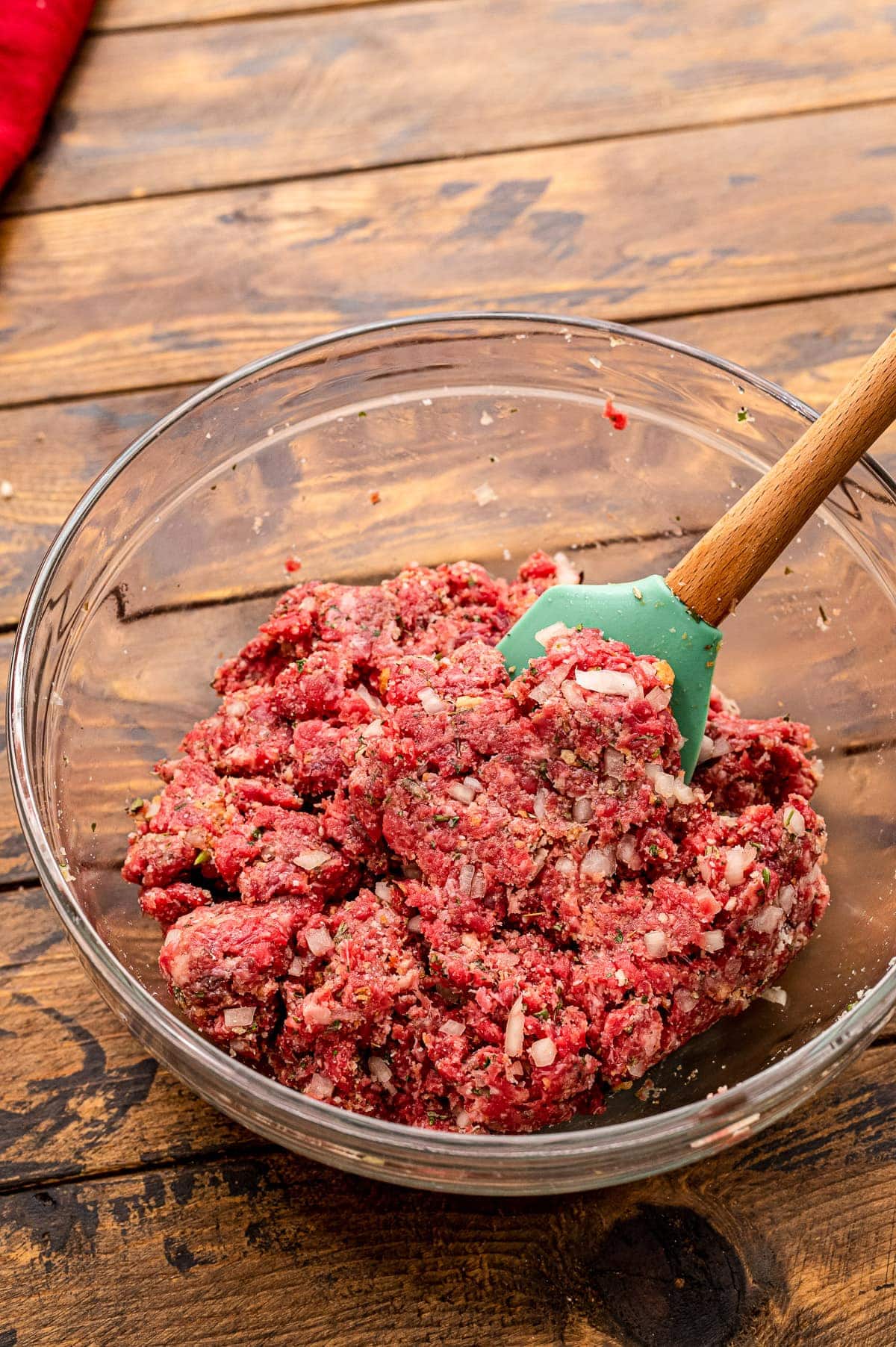 Glass bowl with ingredients mixed up to make homemade meatballs