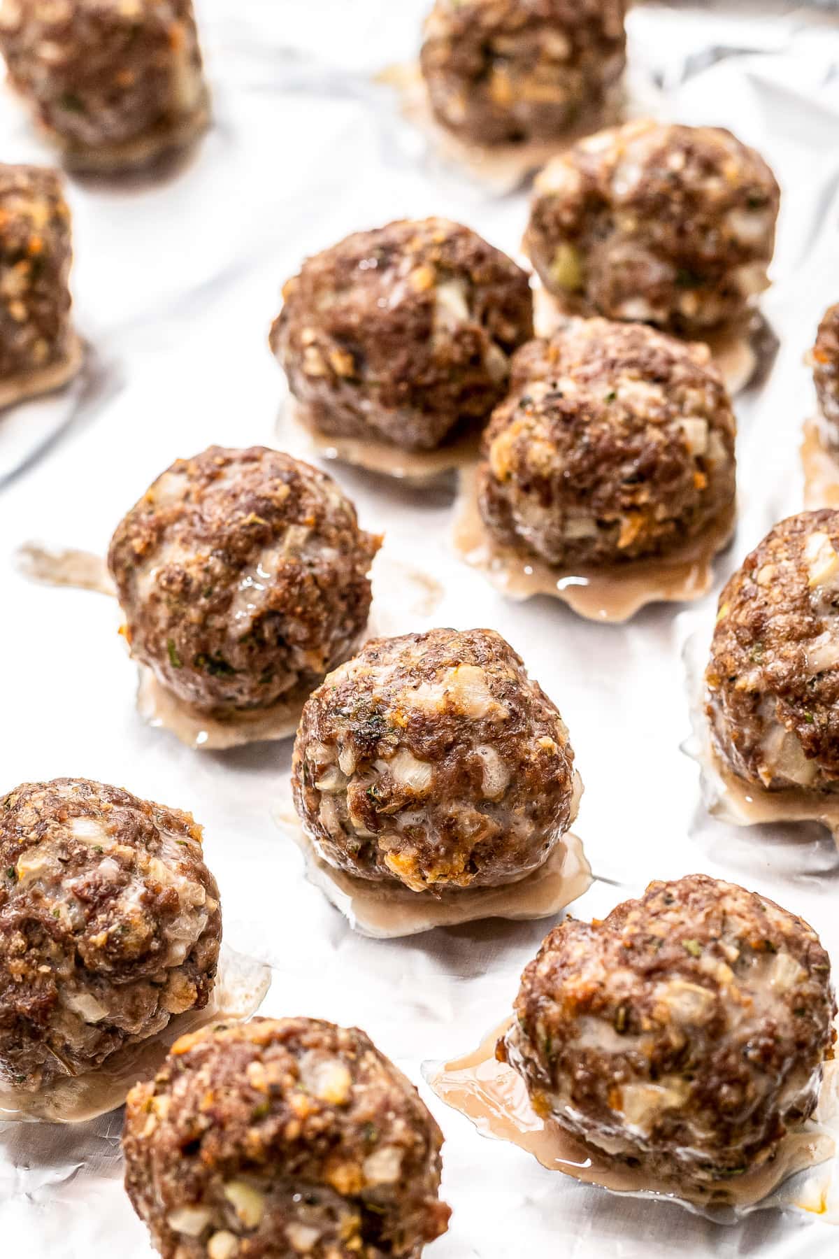 Meatballs on a baking sheet lined with foil after baking