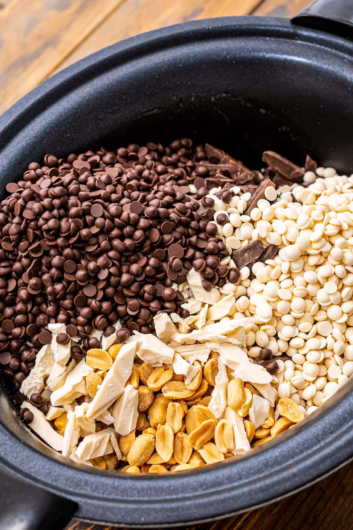 Crock Pot with ingredients for Peanut Clusters before stirring.