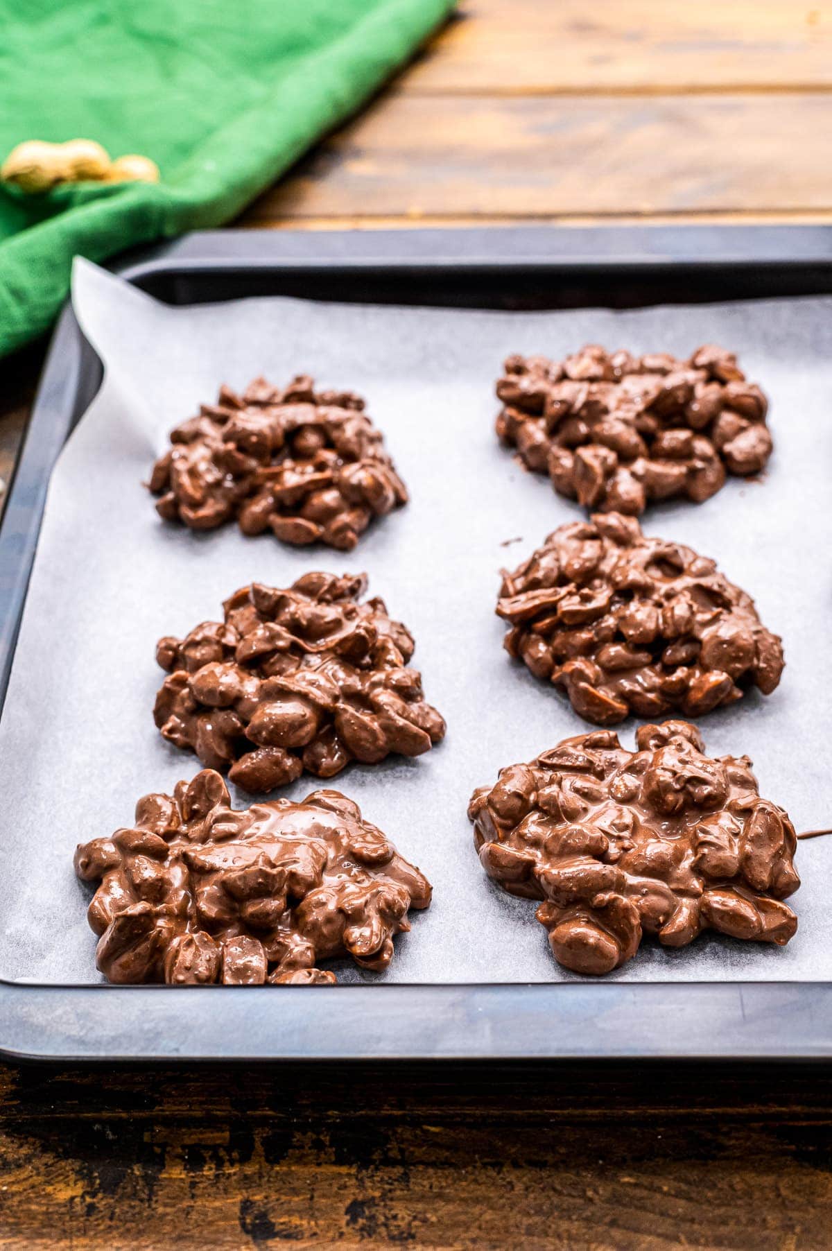 Crock Pot Peanut Clusters Recipe on wax paper on a sheet pan