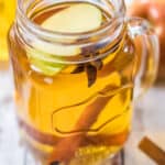 Close up photo of spiked apple cider in glass mason jar mug