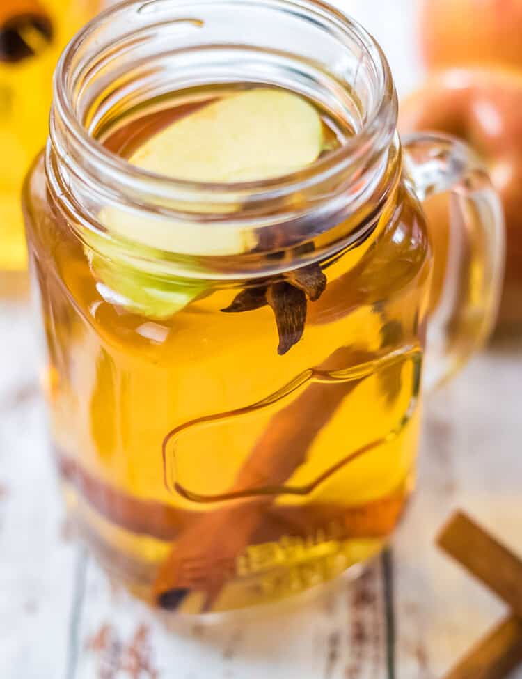 Close up photo of spiked apple cider in glass mason jar mug