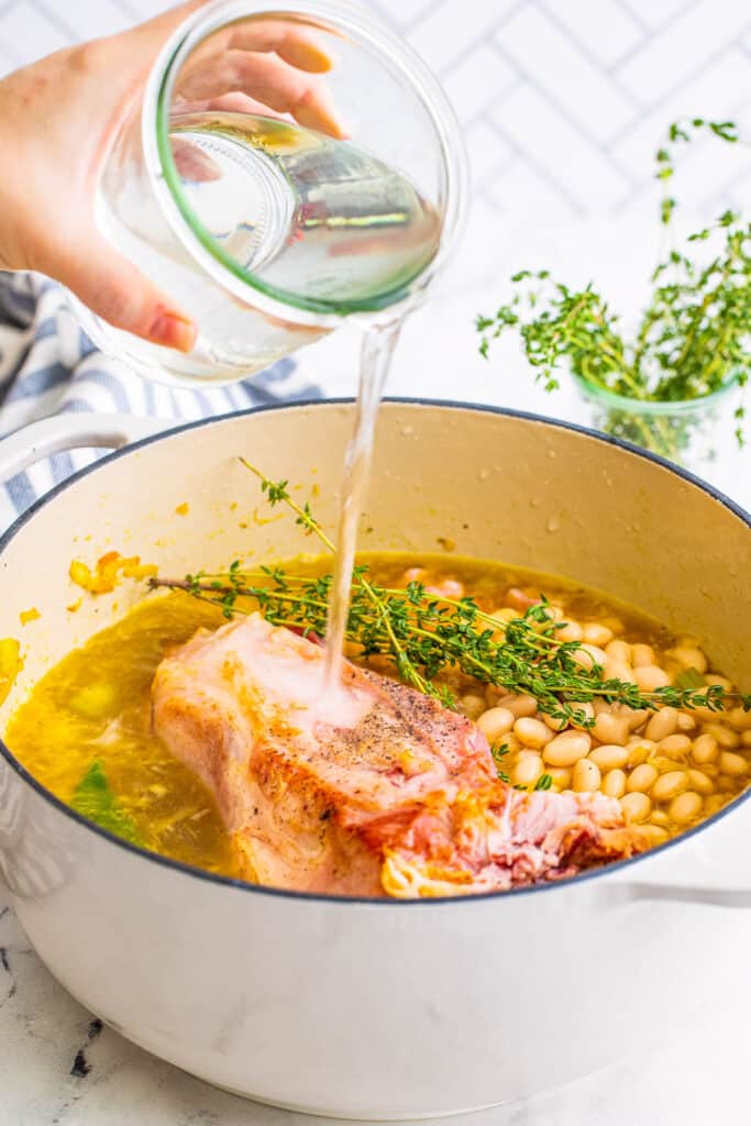 Pouring Water into dutch oven filled with ham bone soup