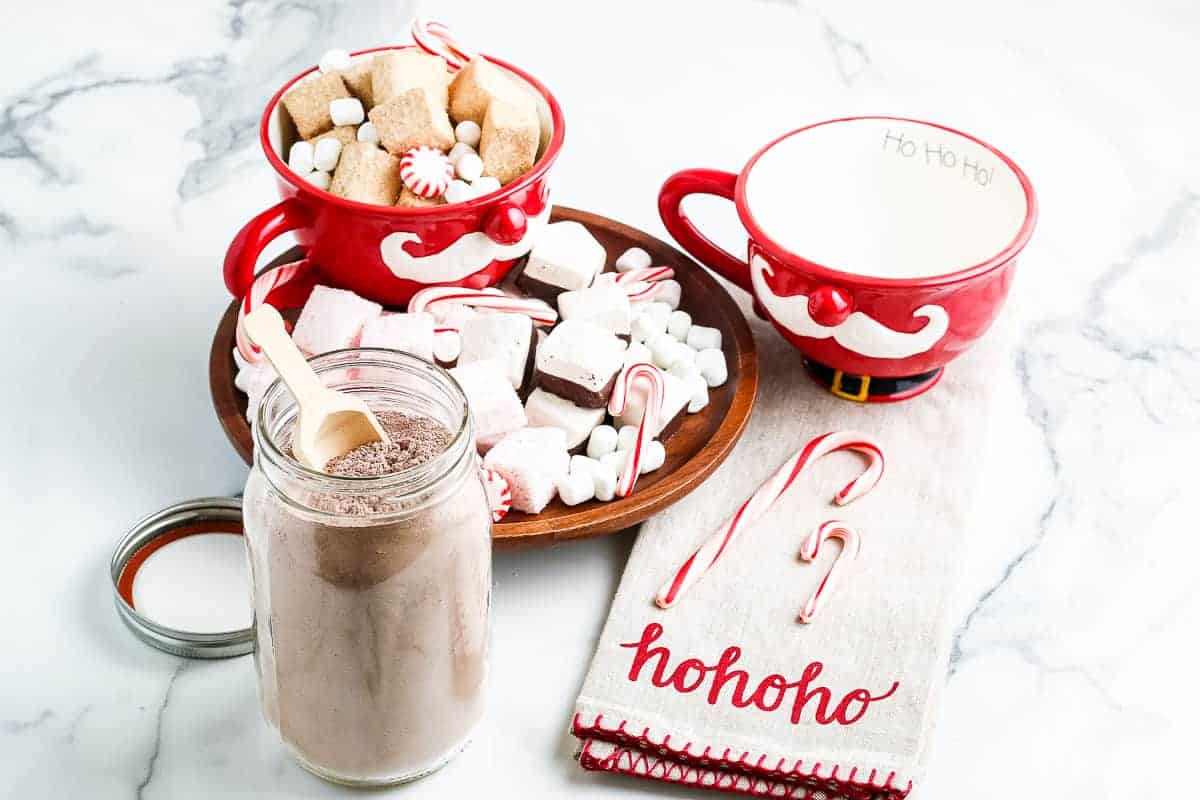 Marble background with homemade hot chocolate mix in container and festive decor