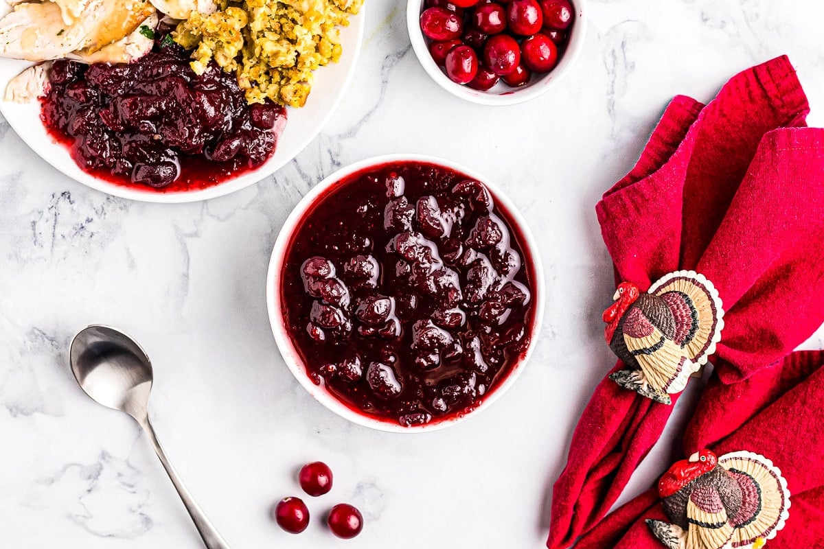 Overhead image of Instant Pot Cranberry Sauce in white bowl on marble background