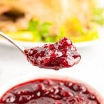 Instant Pot Cranberry Sauce on a spoon with bowl of it in background