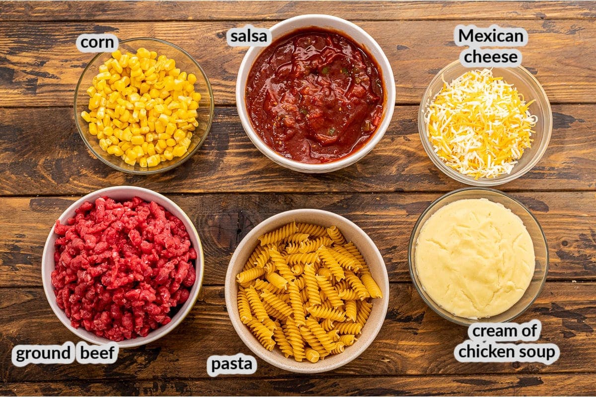 Overhead image of Mexican Pasta Bake Ingredients in bowls on wood background