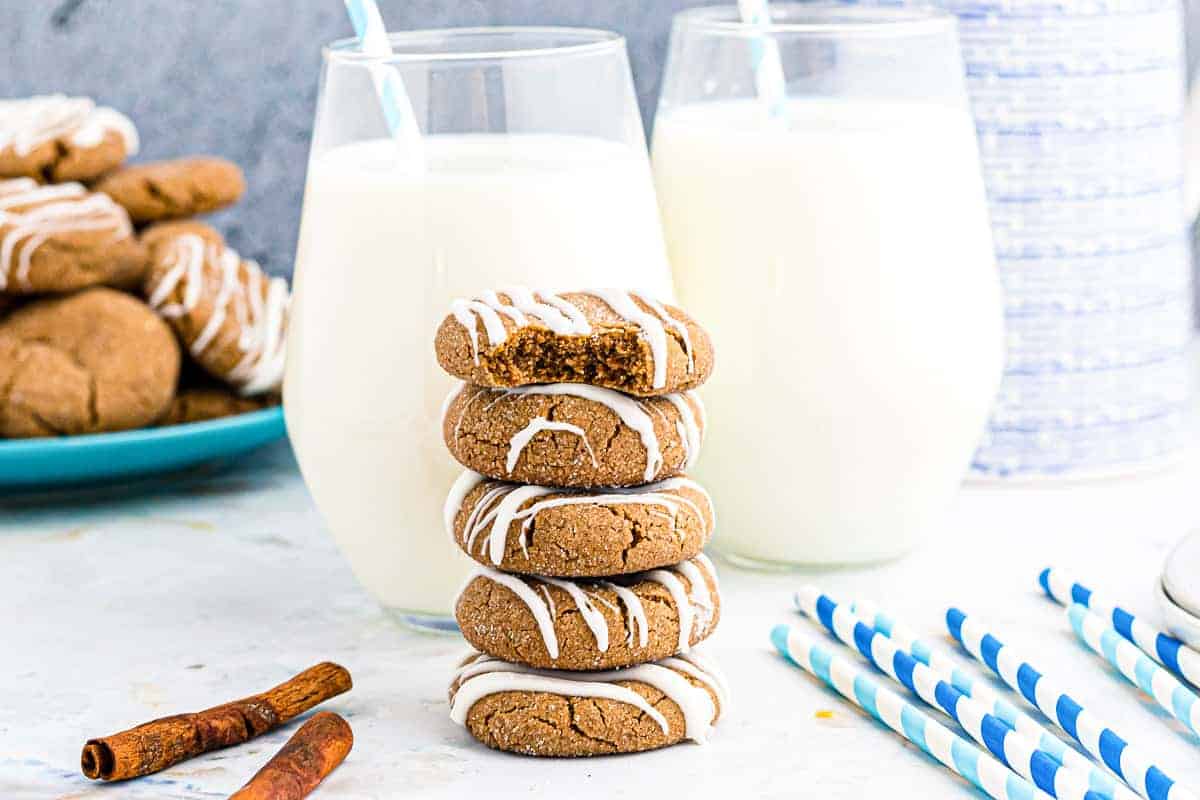 Stack of Molasses Cookies with glasses of milk behind it