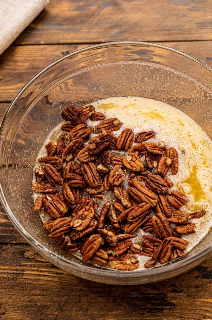 Glass bowl with ingredients for pecan pie before stirring.