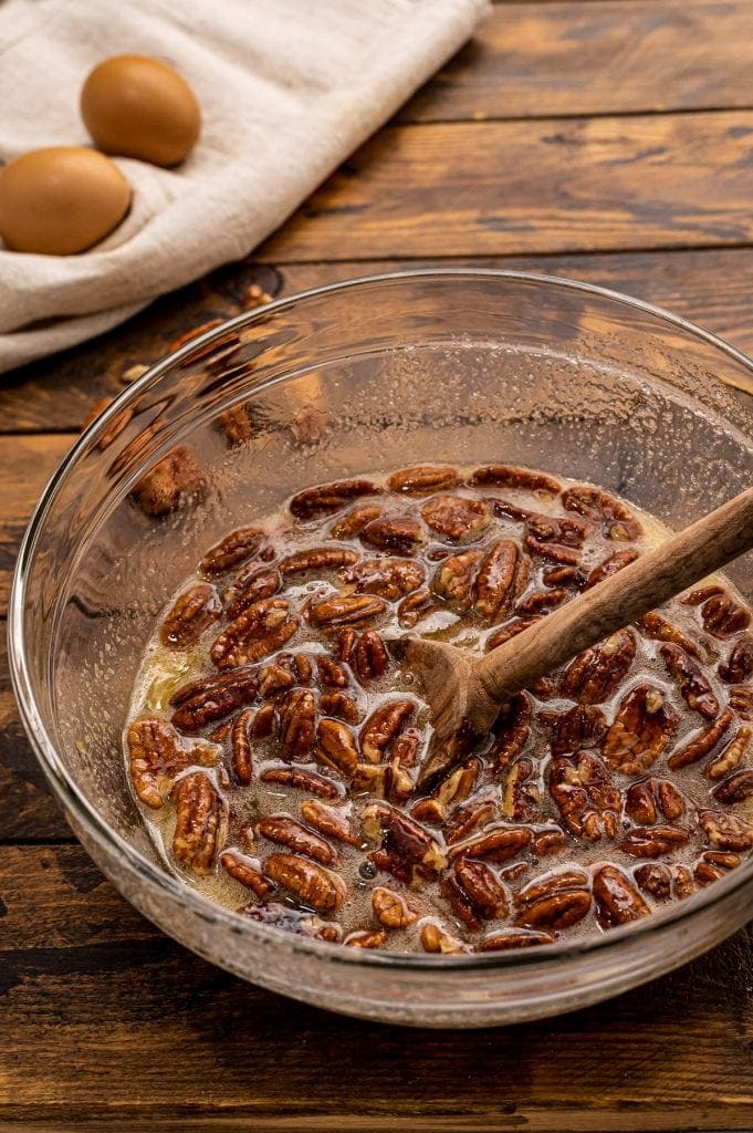 Glass bowl with ingredients for pecan pie after stirring.