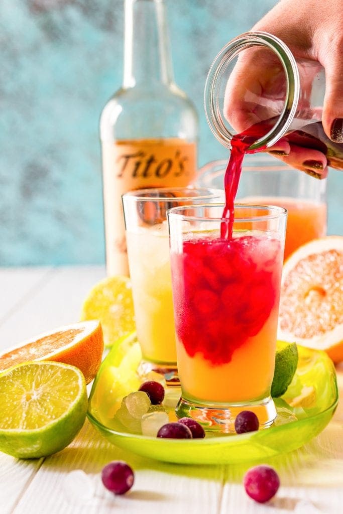 Pouring cranberry juice into cocktail