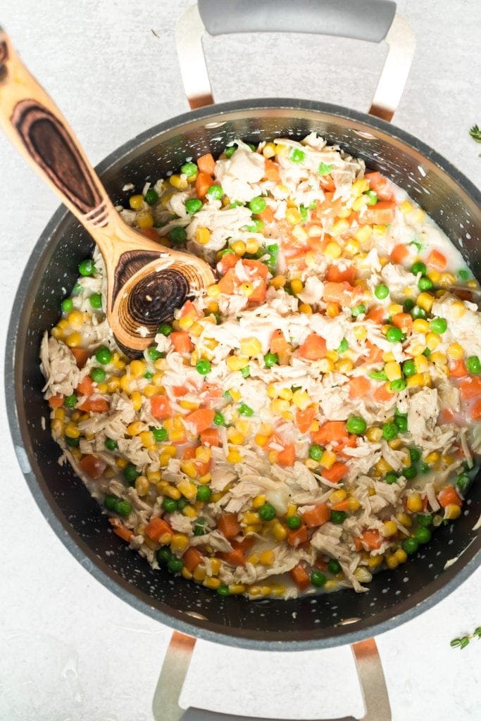 Wooden spoon mixing ingredients for pot pie