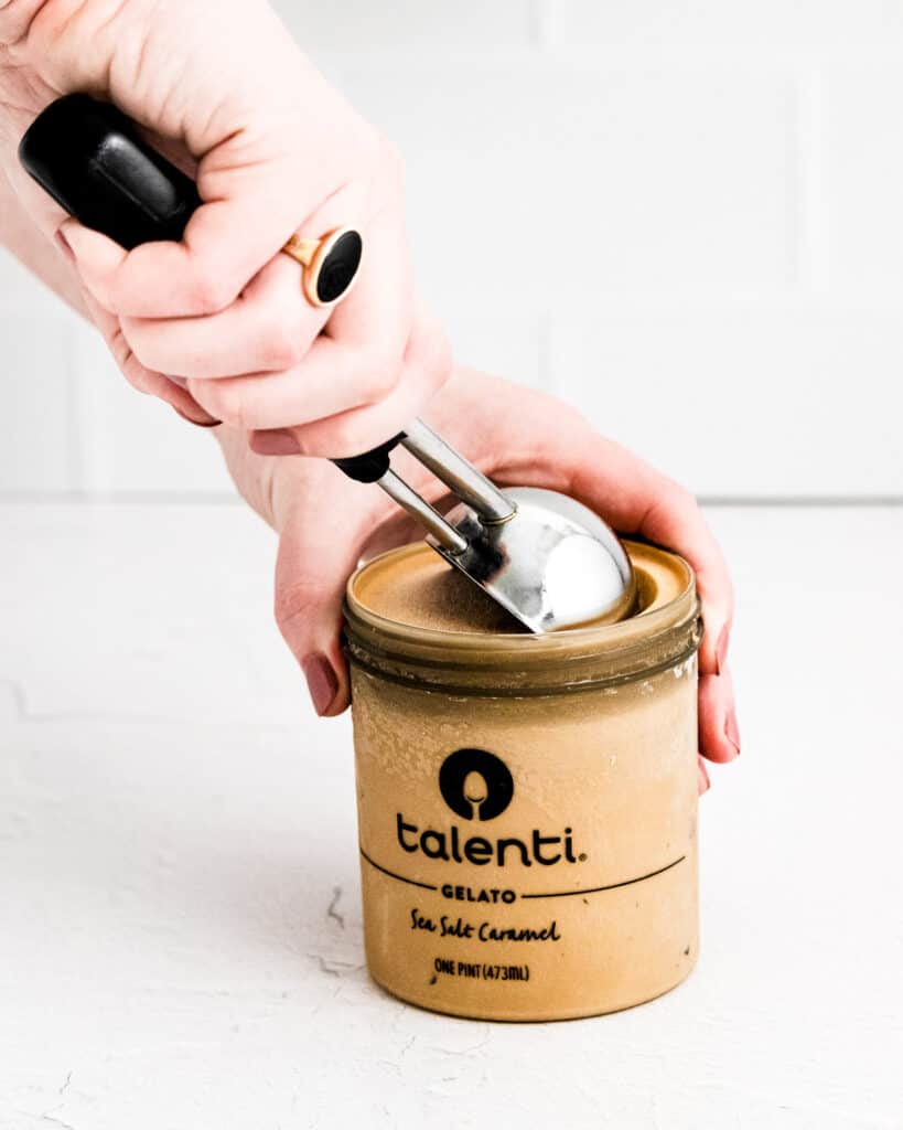 Taking an ice cream scoop of Gelato out of jar