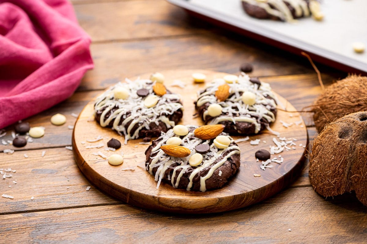 Three Almond Joy Cookies on circular cutting board