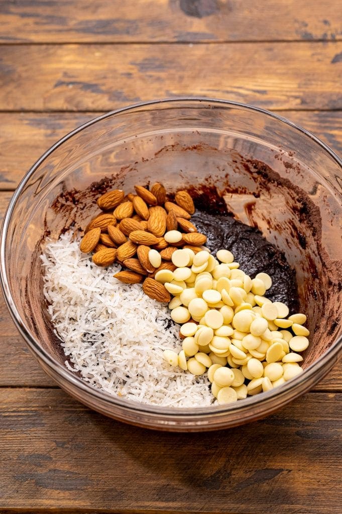 Glass bowl with ingredients to make Almond Joy Cookies before mixing