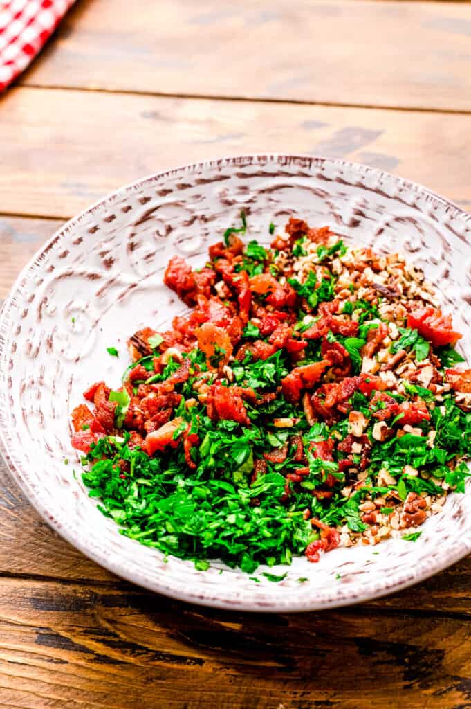 Bowl with bacon, nuts and fresh parsley combined.