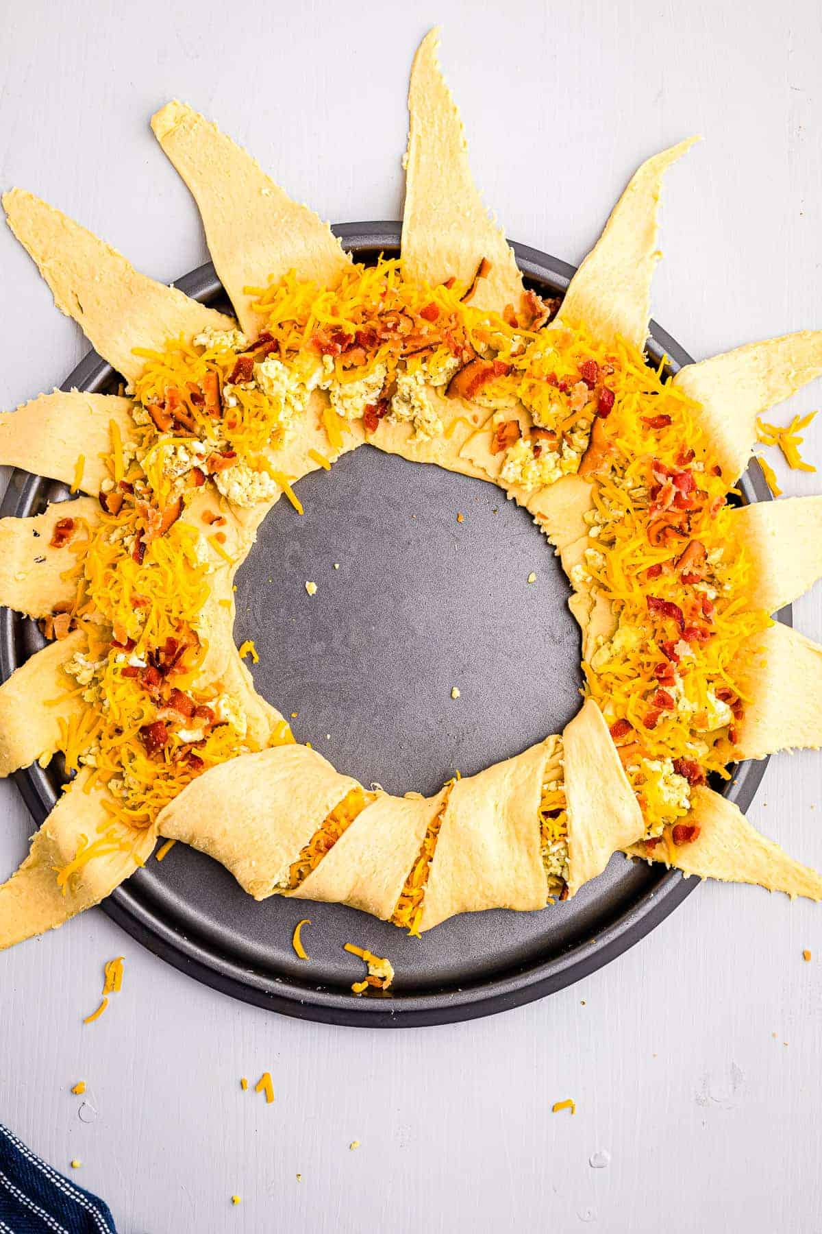 Crescent ring that is filled with cheese, eggs and bacon with a few slices folded over.