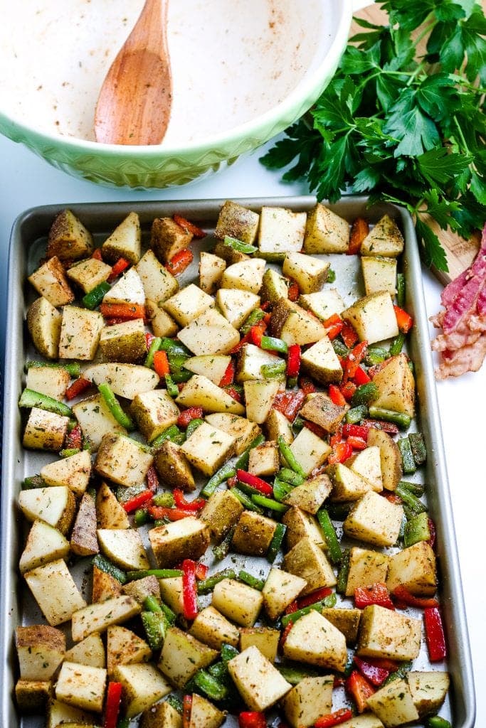 Sheet pan with breakfast potato ingredients on it before baking