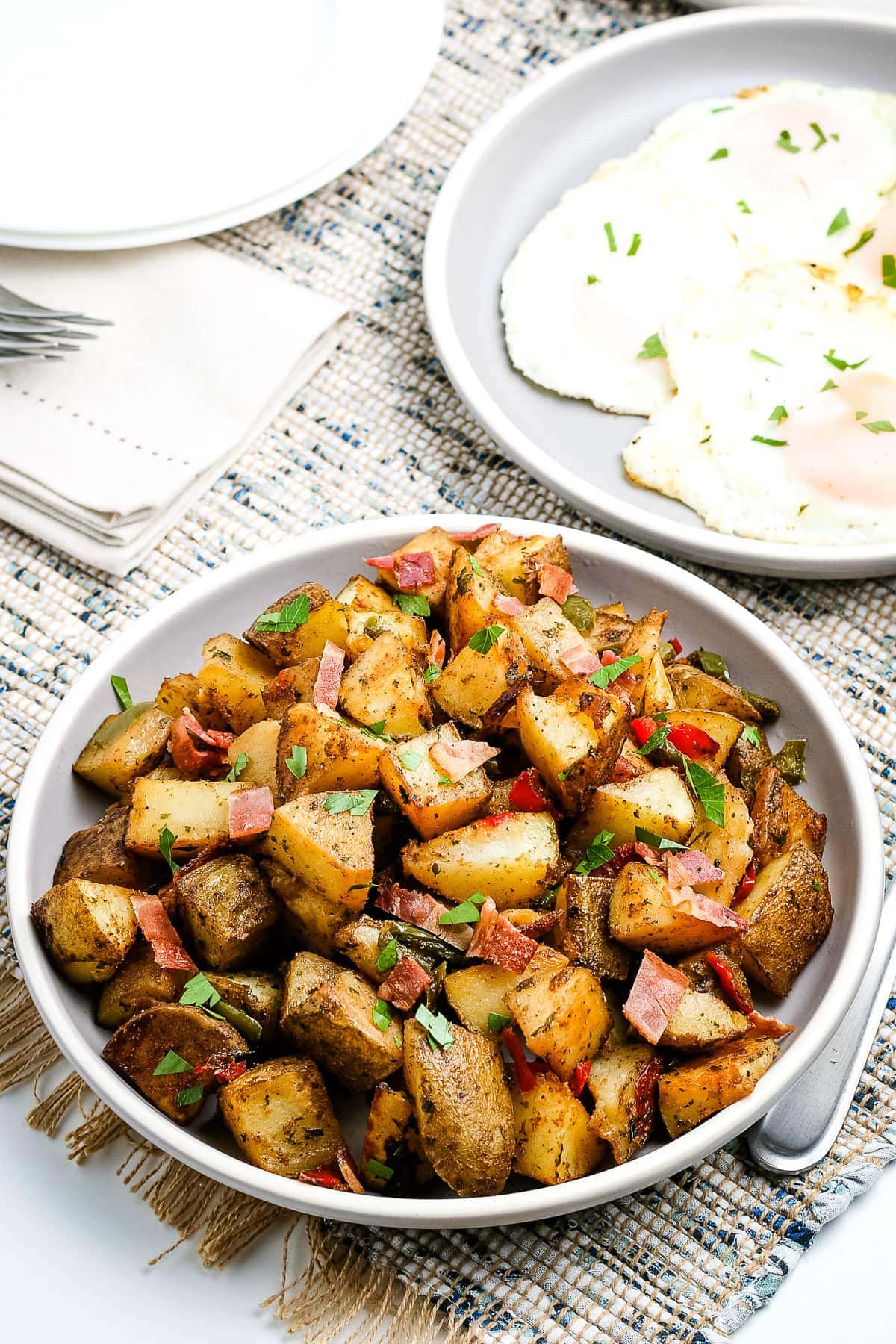 White plate with a dish of breakfast potatoes on it.