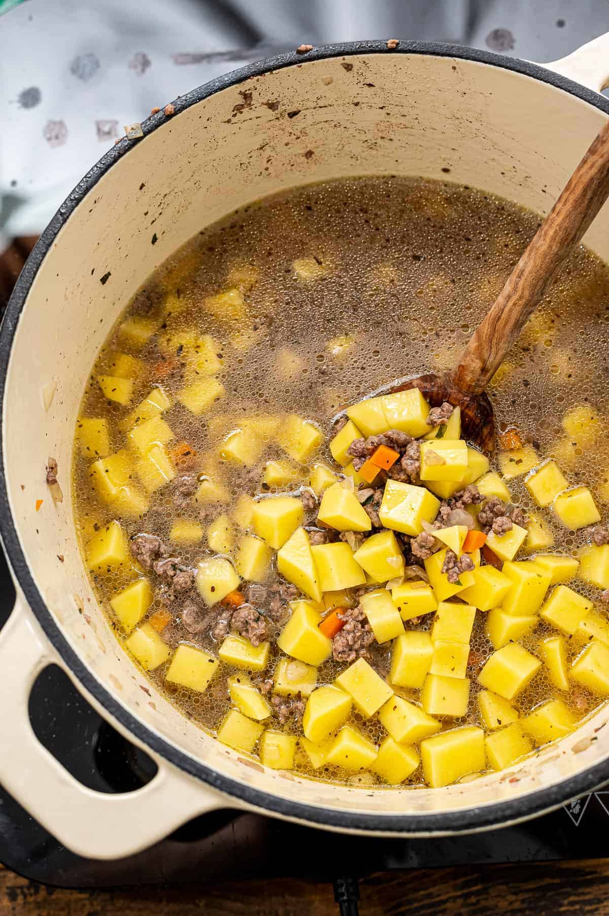 Potatoes in broth in stockpot for soup