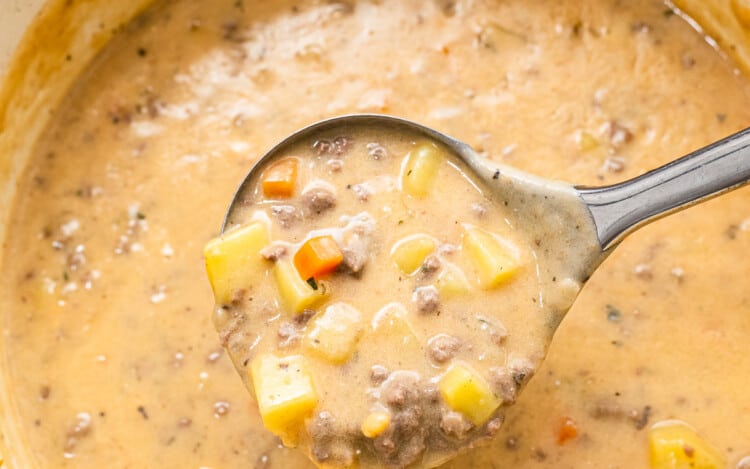 Ladle scooping Cheeseburger Soup out of pot