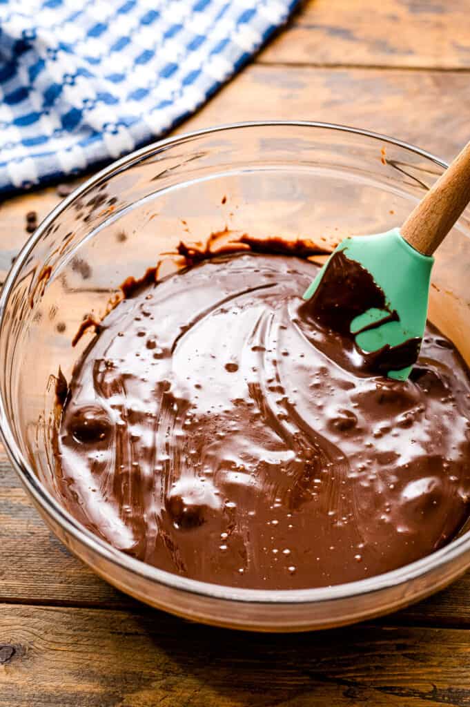 Glass bowl with melted chocolate chips and sweet and condensed milk stirred together