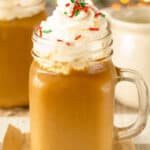 Glass Mug with Christmas Coffee topped with whipped cream and sprinkles