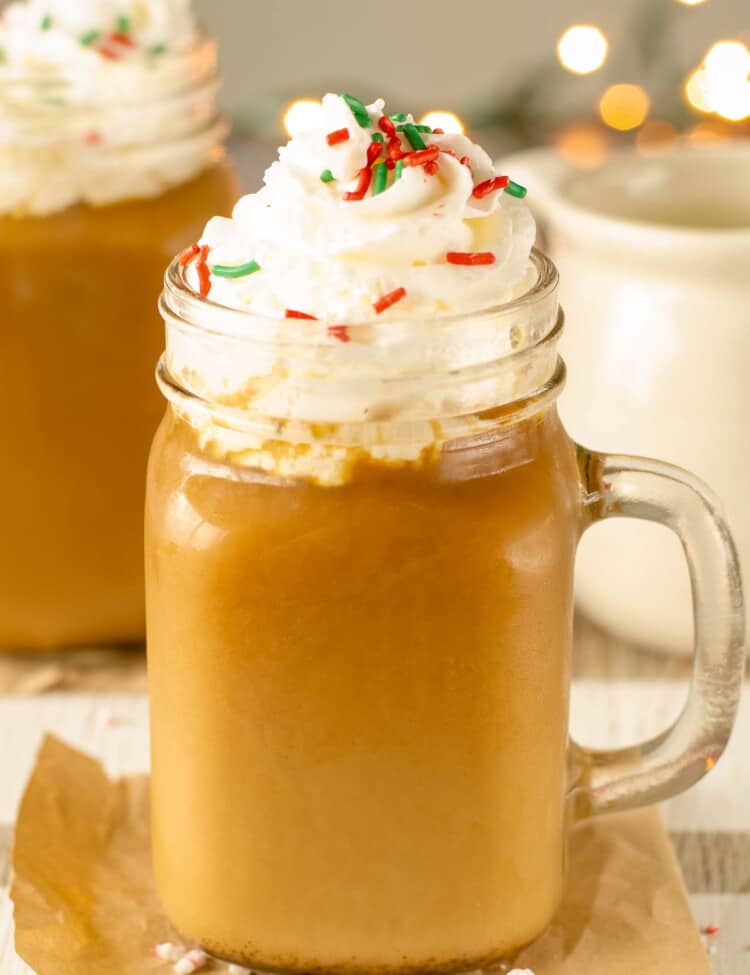 Glass Mug with Christmas Coffee topped with whipped cream and sprinkles