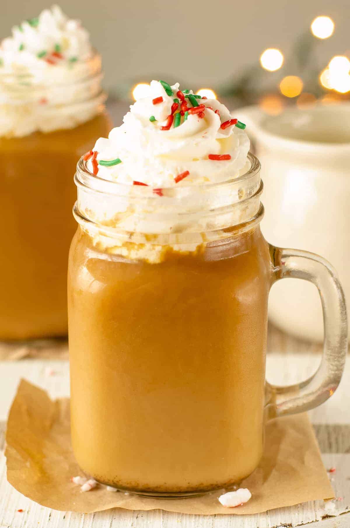 Glass Mug with Christmas Coffee topped with whipped cream and sprinkles