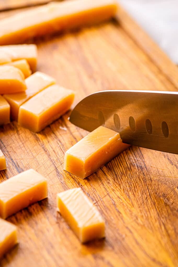 Knife Cutting Homemade caramels on wood cutting board