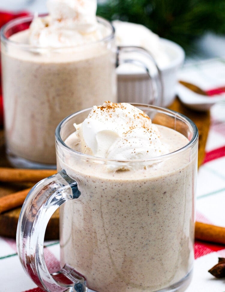 Homemade Eggnog in mugs topped with whipped cream.