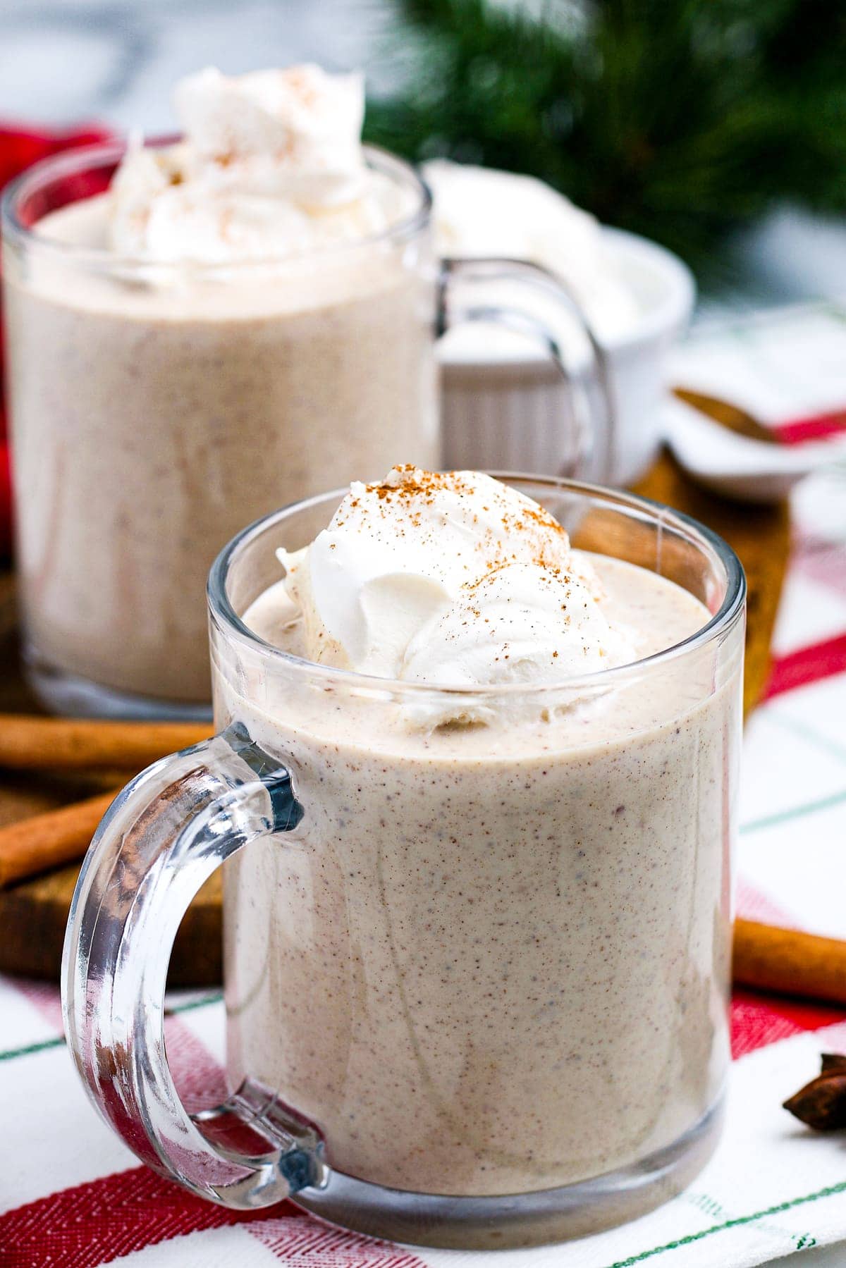 Homemade Eggnog in mugs topped with whipped cream.