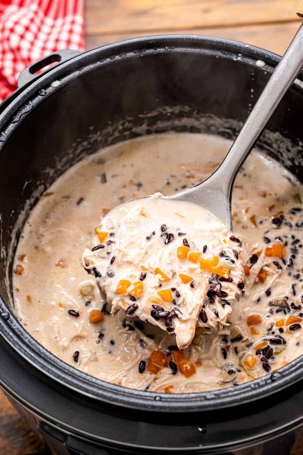 Instant Pot with a ladle scooping Chicken Wild Rice Soup out of it.