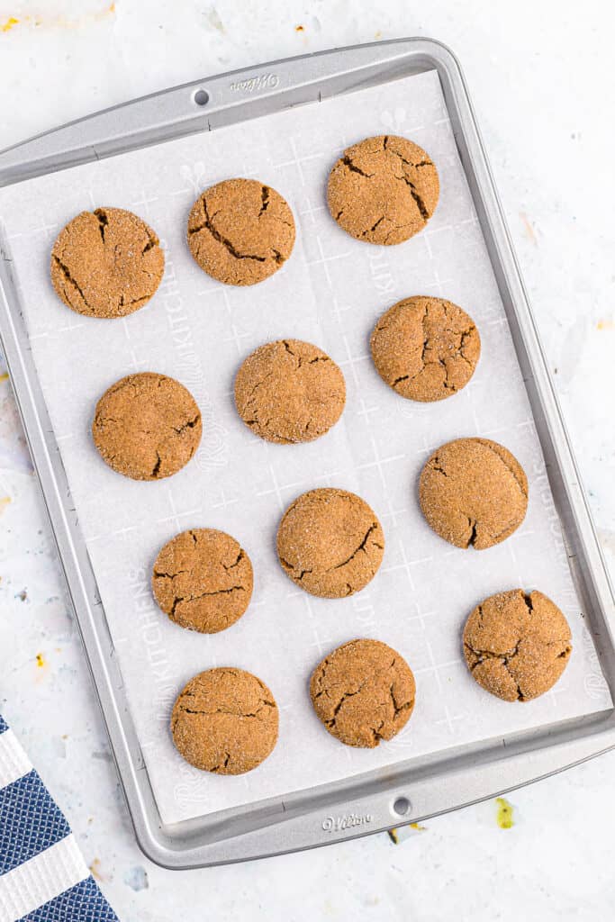 Overhead image of baking sheet with molasses cookies on it baked