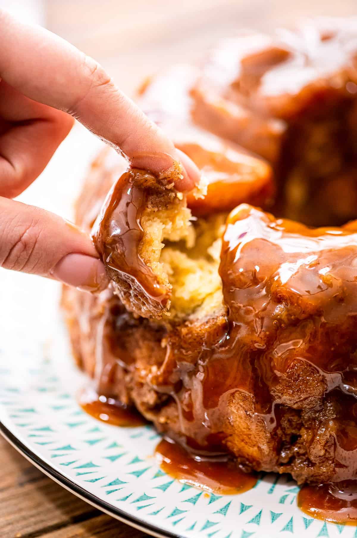 Finger pulling a piece of monkey bread out of pull aparts.