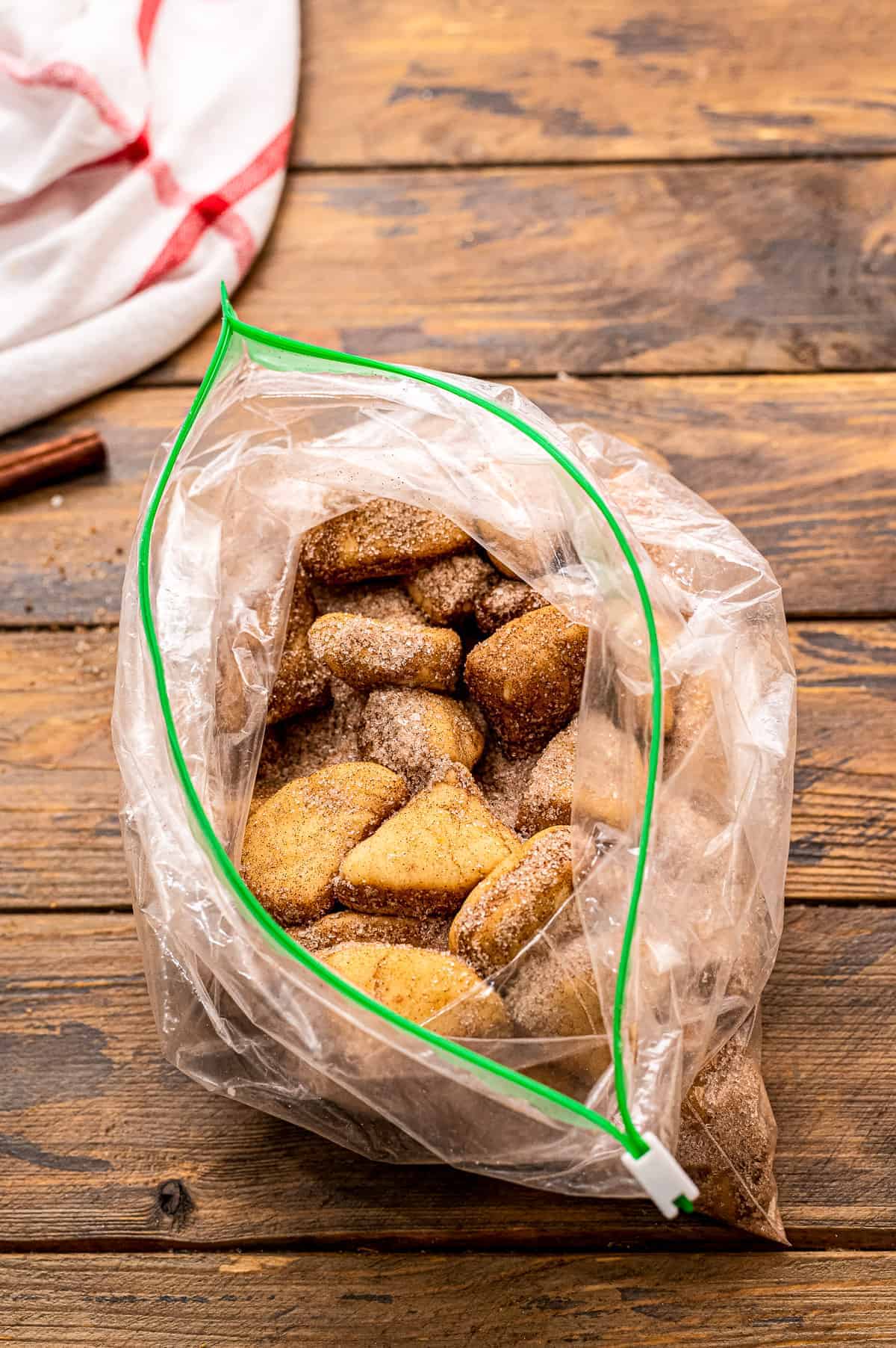 A resealable bag with cinnamon sugar covered biscuit pieces in it