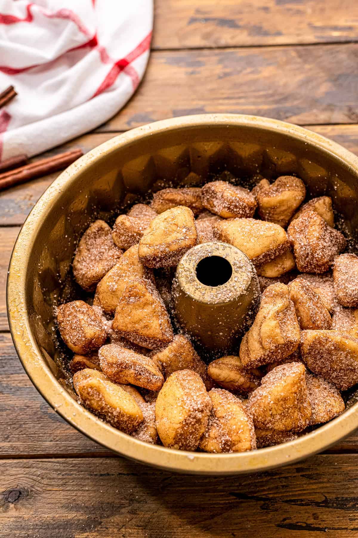 Bundt pan with cinnamon sugar biscuits in it for monkey bread