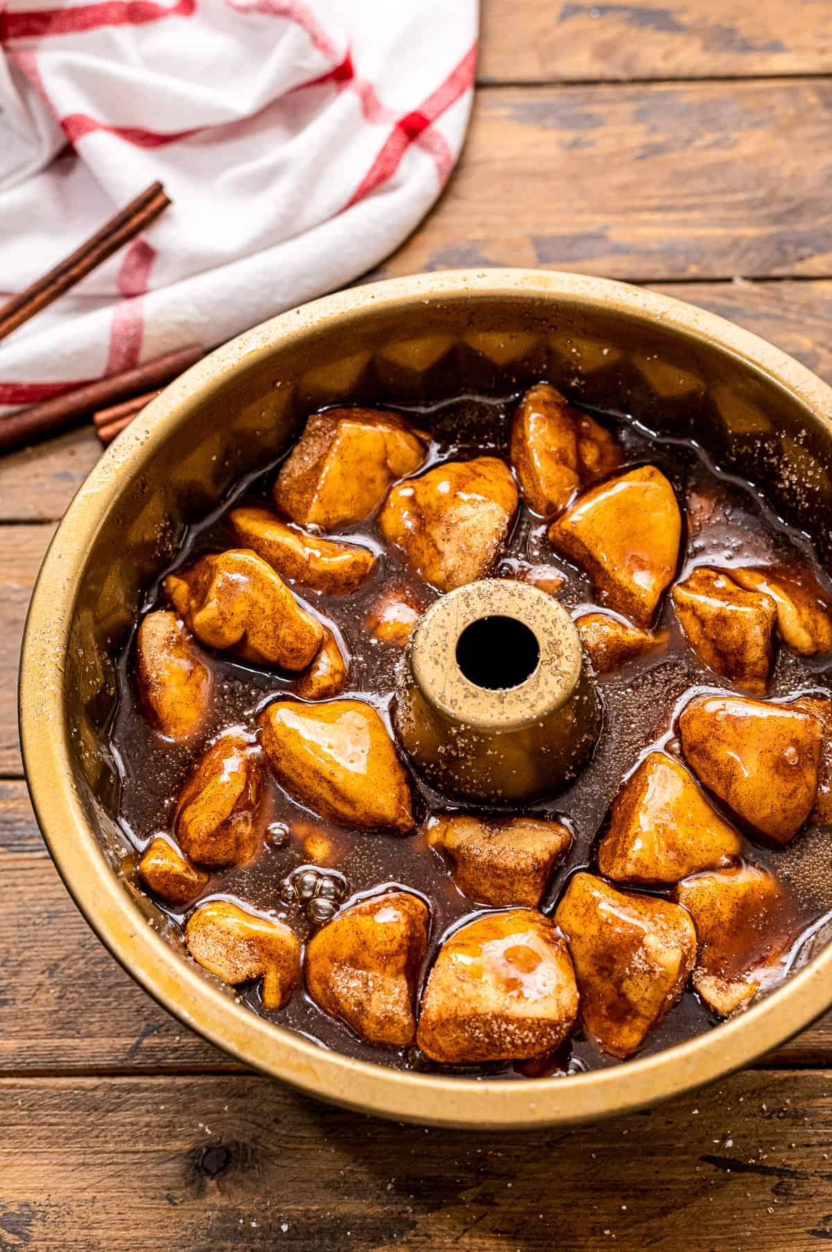 A bundt pan with monkey bread covered with caramel before baking