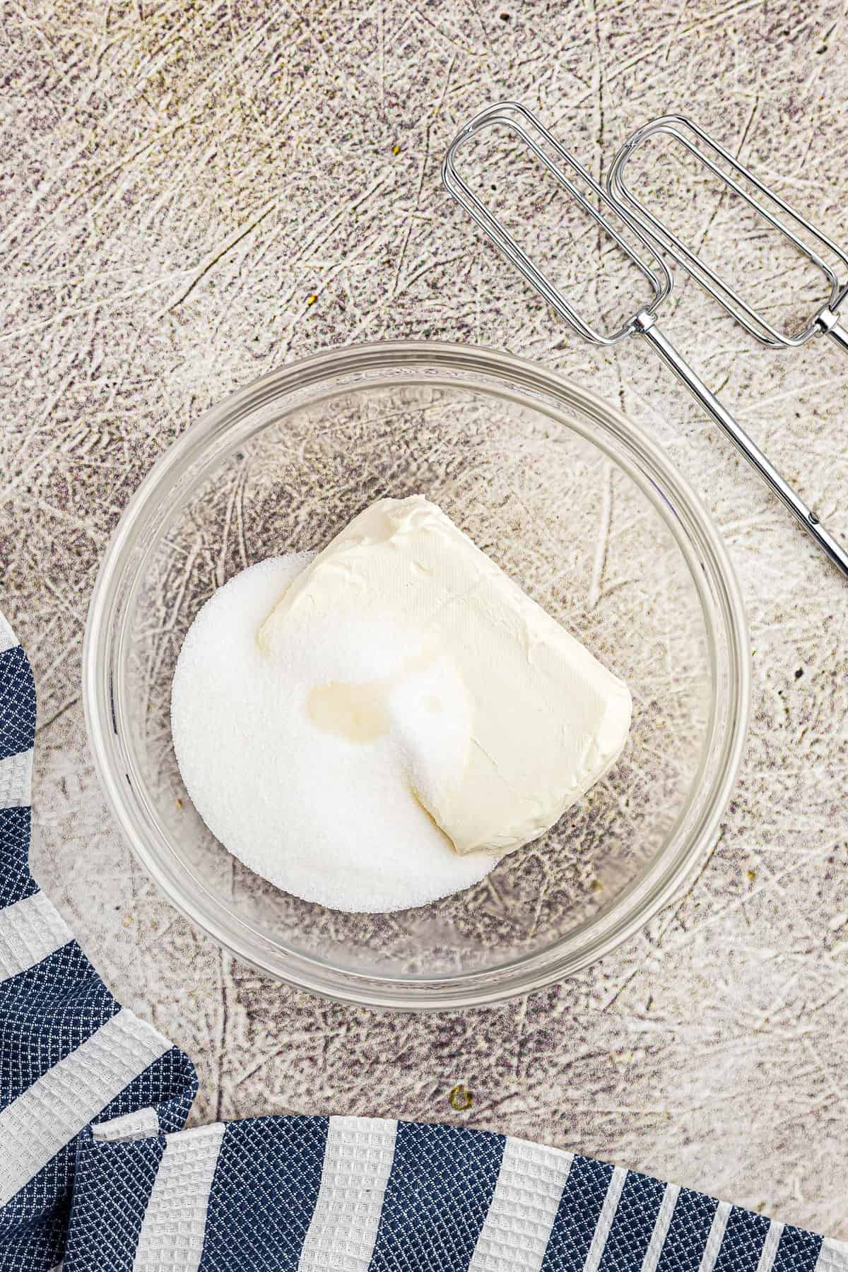 Bowl with cream cheese, sugar and almond extract before mixing