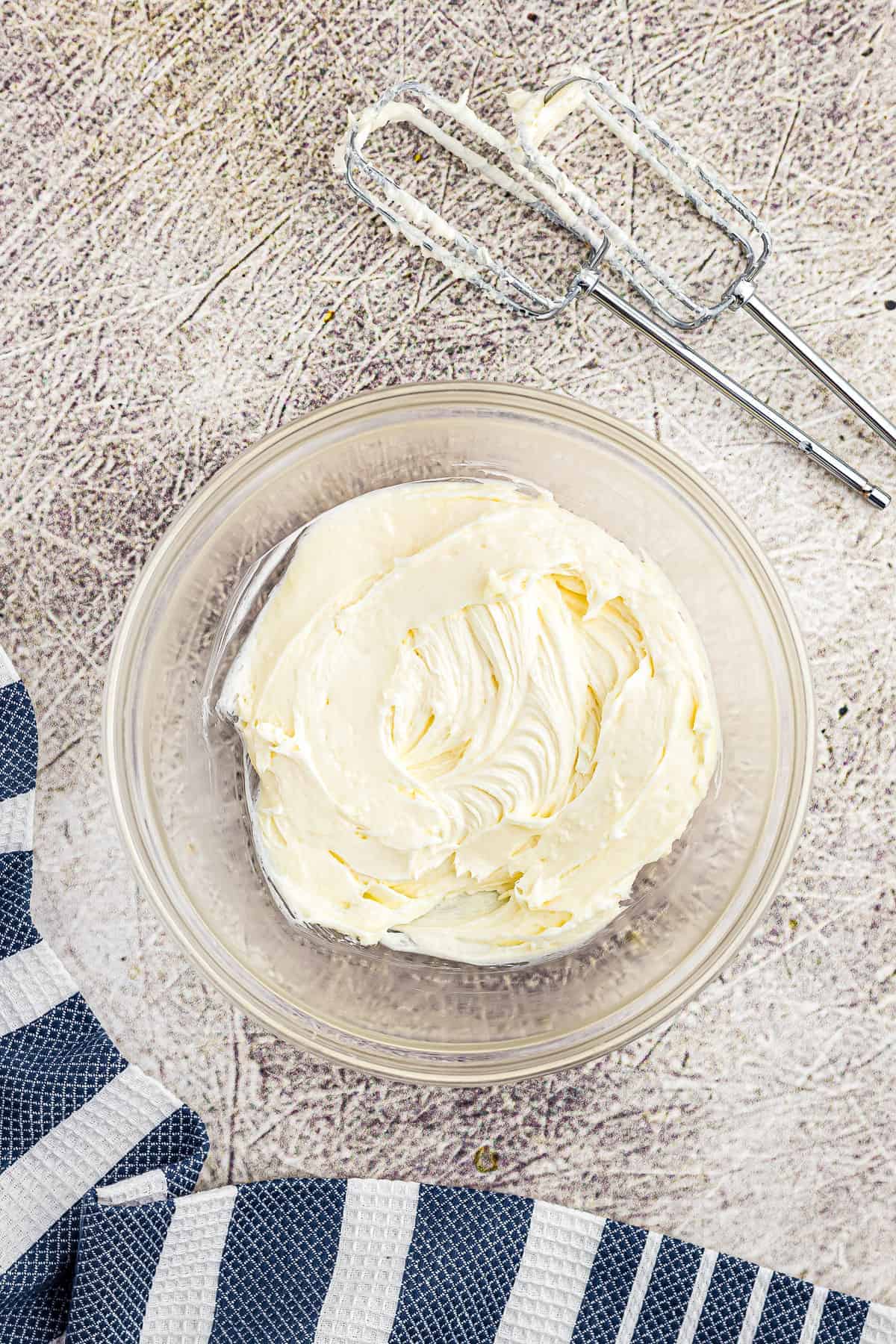 Bowl with cream cheese, sugar and almond extract after mixing