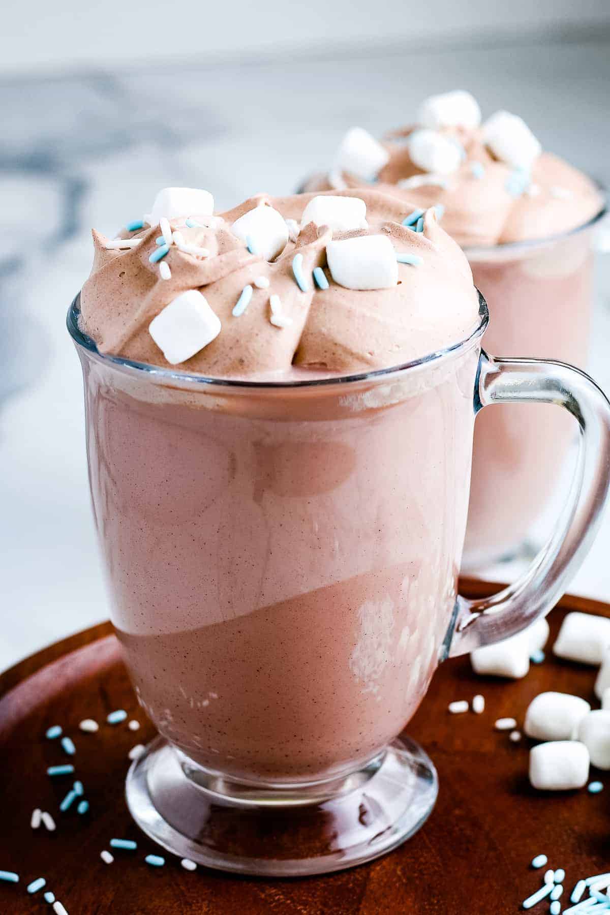 Mug full of Whipped Hot Chocolate topped with marshmallows and sprinkles