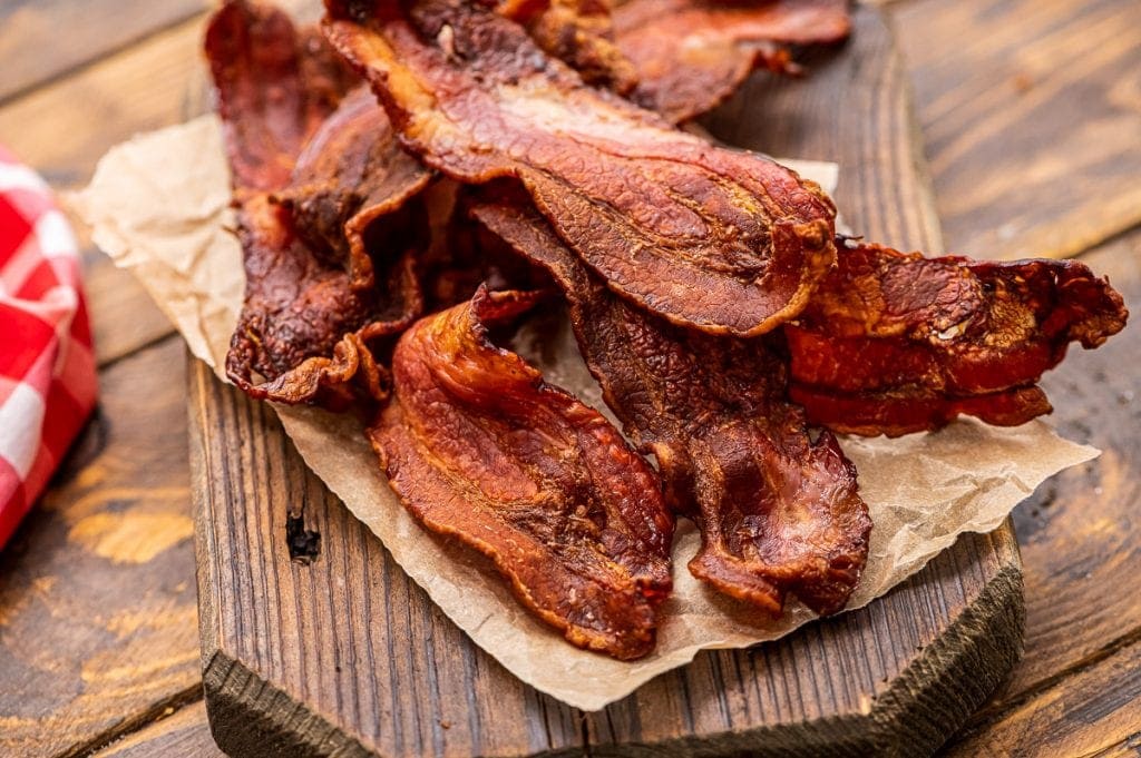 Crispy bacon on paper on top of wood cutting board