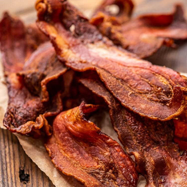 Pile of crispy bacon on top of wood cutting board