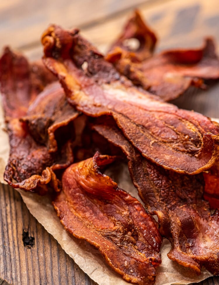 Pile of crispy bacon on top of wood cutting board