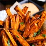 Air Fryer Sweet Potato Fries in a cup and garnished with parsley