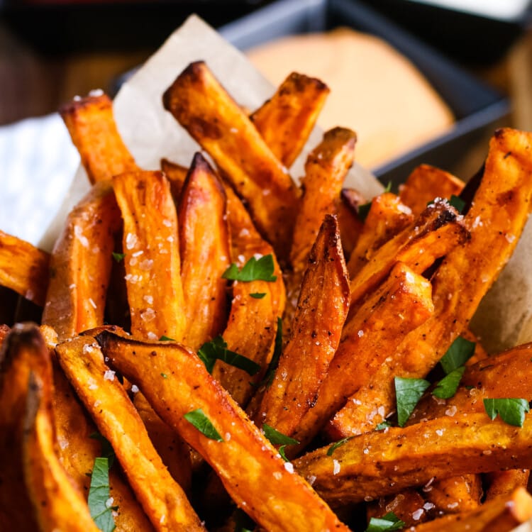 Air Fryer Sweet Potato Fries in a cup and garnished with parsley